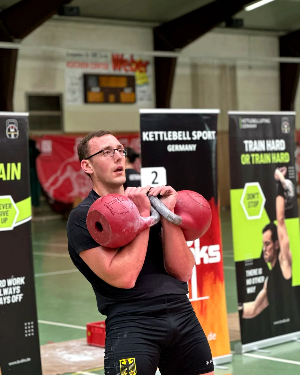 Alexander Jäck mit zwei roten Kettlebells in der Rack-Position