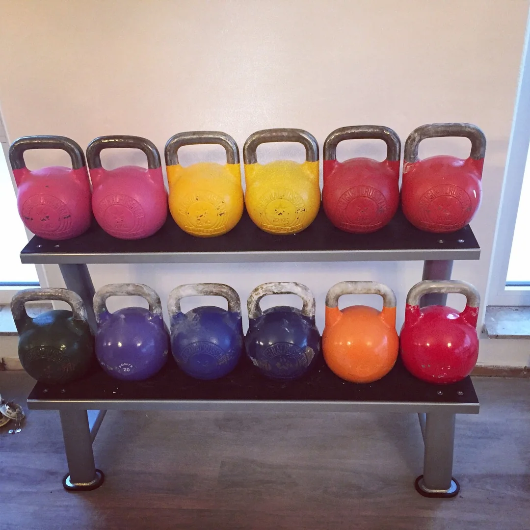 Verschiedenfarbige Wettkampf-Kettlebells auf einem zweistufigen Ständer